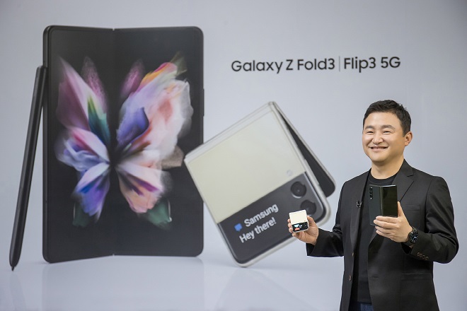 This photo provided by Samsung Electronics Co. on Aug. 11, 2021, shows Roh Tae-moon, head of Samsung's mobile communications business, holding the Galaxy Z Fold3 and the Galaxy Z Flip 3 at the Galaxy Unpacked event.