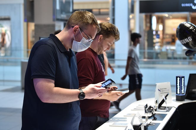 This photo provided by Samsung Electronics Co. on Aug. 27, 2021, shows American shoppers checking the company's Galaxy Z Fold3 and Galaxy Z Flip3 foldable smartphones at the Samsung Experience Store in Garden City, New York.