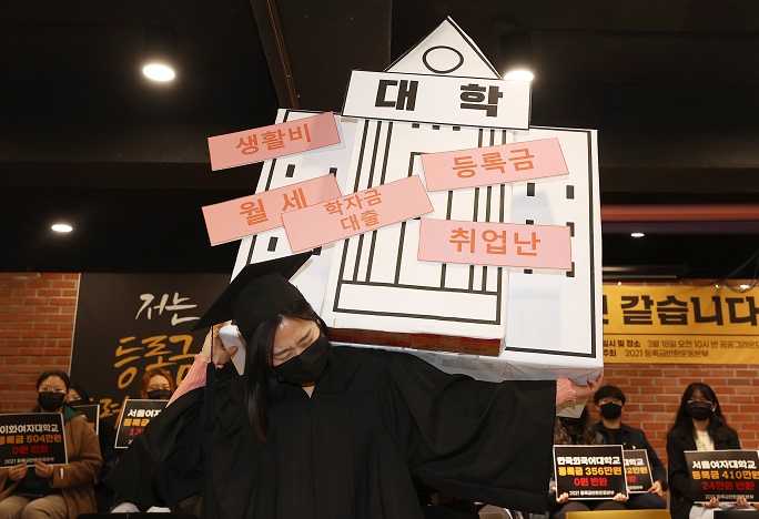 This March 18, 2021, file photo shows a student delivering a performance depicting the heavy financial burden of attending college during a news conference held in central Seoul. (Yonhap)