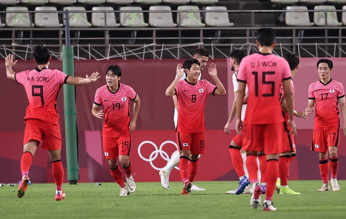 Lee Kang-in (C), a midfielder of South Korea's men's football squad, celebrates with his teammates after scoring the team's fourth goal during a Group B match against Romania at the Tokyo Olympics on July 25, 2021, in Kashima, some 110 kilometers northeast of Tokyo. South Korea won the match 4-0. (Yonhap)