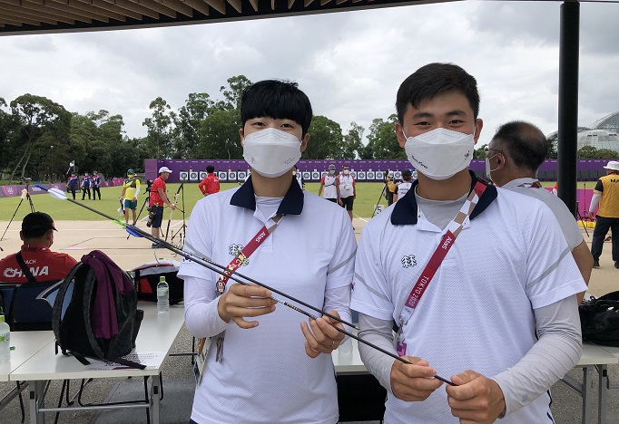 South Korean archers An San (L) and Kim Je-deok pose with their "Robin Hood" arrows from the Tokyo Olympic mixed team archery competition at Yumenoshima Park Archery Field in Tokyo on July 31, 2021, before donating them to the International Olympic Committee's Olympic Museum in Switzerland, in the photo provided by the Korea Archery Association on Aug. 1.
