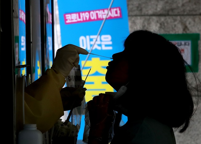 A health worker conducts a new coronavirus screening test at a walk-in center set up in central Seoul on Aug. 3, 2021. (Yonhap)