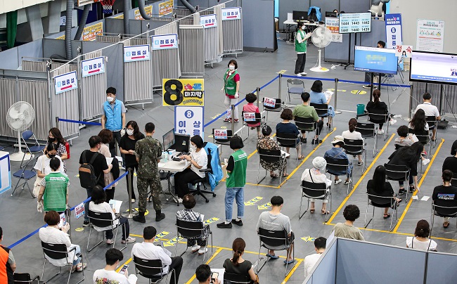 People wait in line to receive COVID-19 vaccines at an inoculation center in southern Seoul on Aug. 6, 2021. (Yonhap)