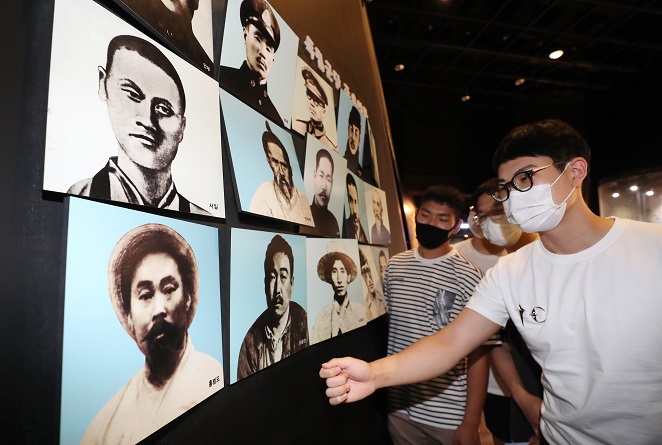 Visitors look at photos of Korean independence fighters including Hong Beom-do (L, 1st row) at the Independence Hall of Korea in Cheonan, 90 kilometers south of Seoul, on Aug. 13, 2021, two days ahead of the 76th anniversary of Korea's liberation from the 1910-45 Japanese colonial rule of the Korean Peninsula. (Yonhap)
