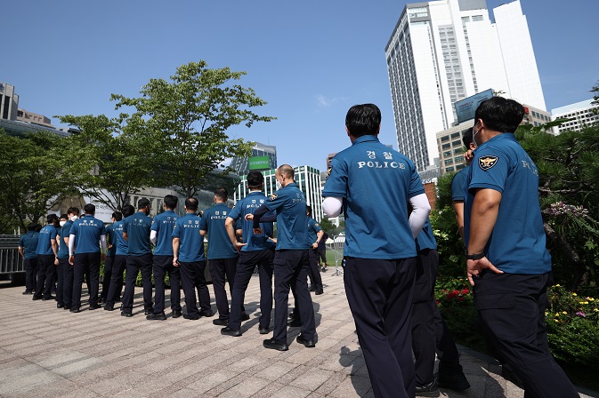 This photo taken on Aug. 16, 2021, shows police officers waiting to take a coronavirus test at a makeshift testing facility in downtown Seoul. (Yonhap)