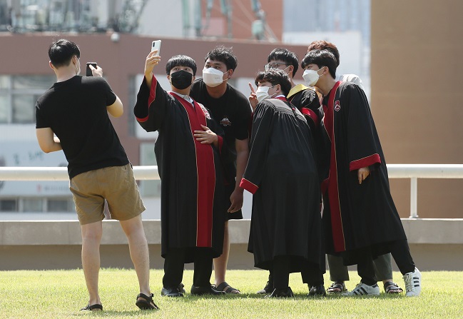 This photo taken on Aug. 17, 2021, shows graduates of Sogang University, in western Seoul, taking pictures of themselves on campus amid the extended COVID-19 pandemic. (Yonhap)