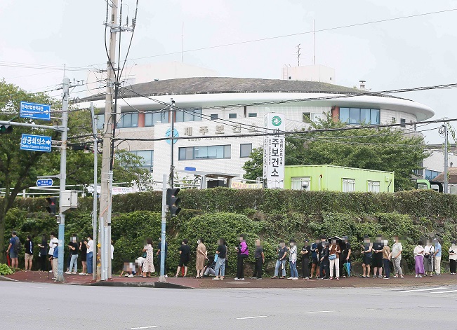 People wait to be tested at a COVID-19 testing station on the country's southern island of Jeju on Aug. 23, 2021, with the country reporting 1,418 new cases on the day. (Yonhap)
