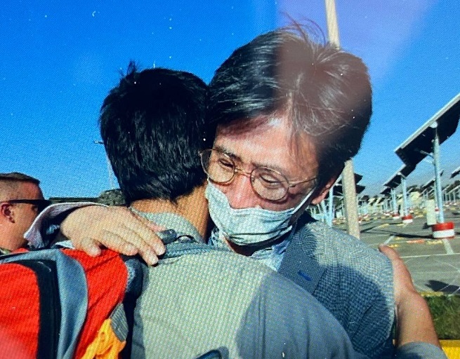 Minister Counsellor Kim Il-eung of the South Korean Embassy in Kabul hugs an Afghan as he leads an evacuation mission in this undated photo, released on Aug. 25, 2021, by the foreign ministry.