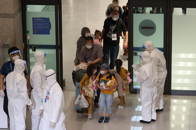 Afghan evacuees exit an arrival gate at Incheon International Airport, west of Seoul, on Aug. 26, 2021. (Yonhap)