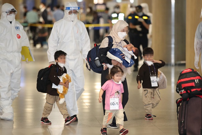 An Afghan family walks through the arrival gate at Incheon International Airport, west of Seoul, on Aug. 26, 2021. South Korea airlifted the families of Afghans who worked at the country's embassy and other facilities in the war-torn nation after the Taliban's seizure of power. (Yonhap)