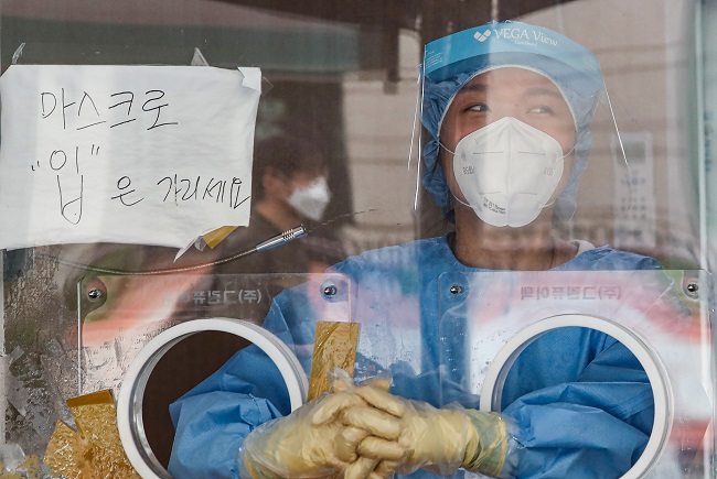 A medical worker waits to carry out COVID-19 tests at a makeshift clinic in central Seoul on Aug. 28, 2021. (Yonhap)