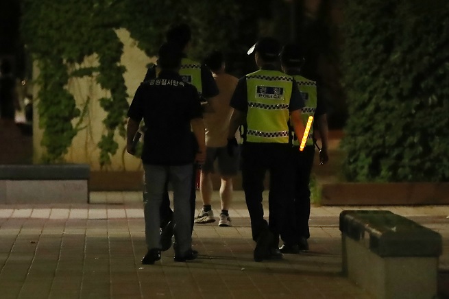 This July 16, 2021, file photo shows police officers patrolling Han River park in eastern Seoul at night. (Yonhap)