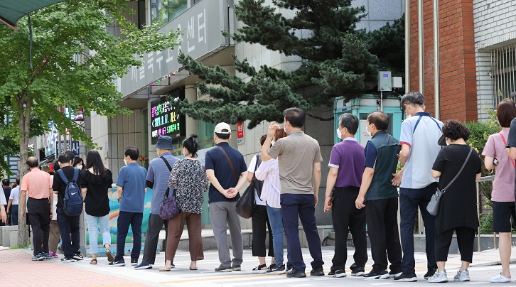 This Aug. 9, 2021, file photo shows people lined up in front of an employment center in northern Seoul to apply for unemployment benefits. (Yonhap)