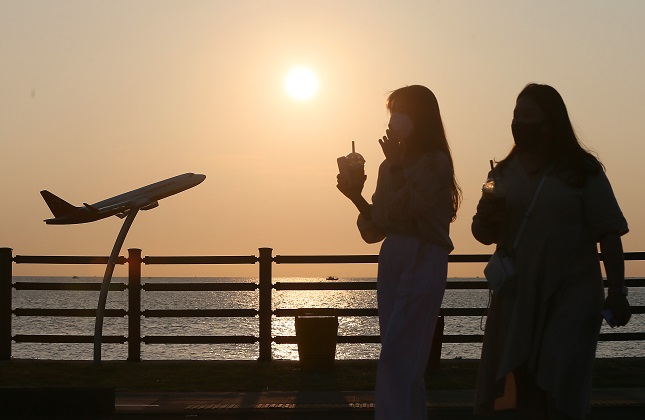 This Aug. 18, 2021, file photo shows two women standing on a beach deck on the southern resort island of Jeju. (Yonhap)