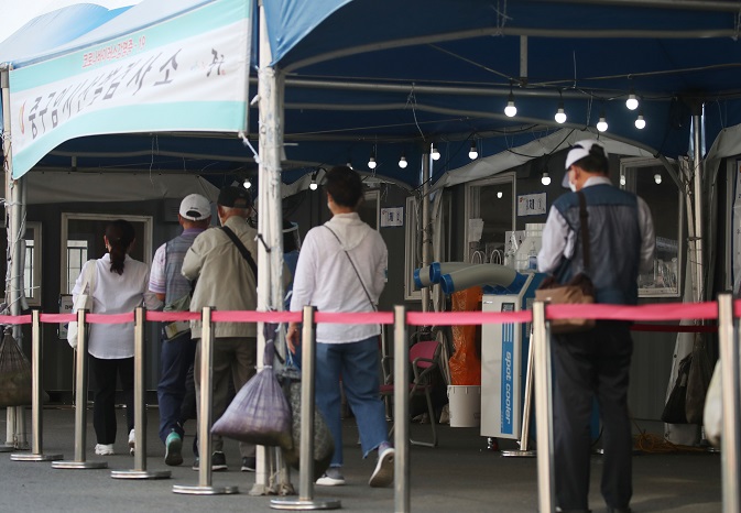 People stand in line to get COVID-19 tests at a screening station in front of Seoul Station on Sept. 4, 2021. (Yonhap)