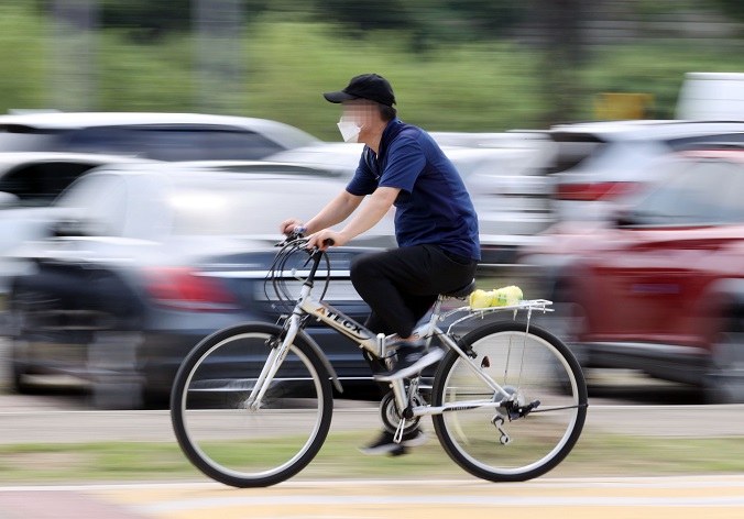 This Sept. 9, 2021, photo shows a man riding a bicycle in a Han River park in southern Seoul. (Yonhap)
