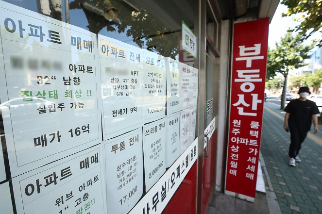 A person passes by a real estate agent's office in Seoul on Sept. 12, 2021. (Yonhap)