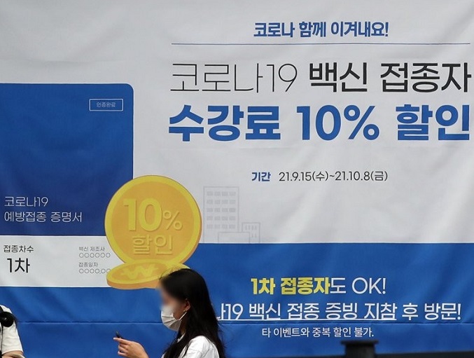 A banner informing of a 10 percent off tuition fee for vaccinated people is put up at a private educational institute in western Seoul on Sept. 28, 2021. (Yonhap)