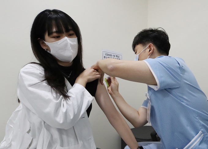 A health worker at Seoul National University Hospital is given a COVID-19 booster shot on Oct. 25, 2021. (Yonhap)