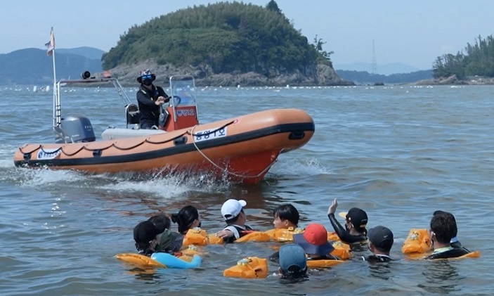 This photo provided by the Ministry of the Interior and Safety shows government officials demonstrate smart buoyancy band.