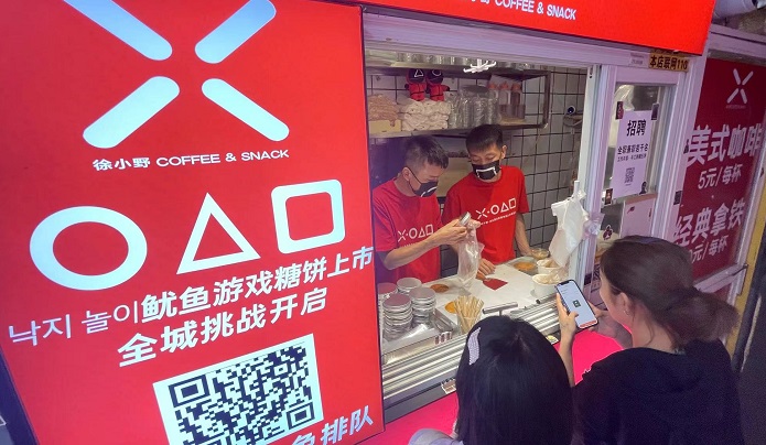 Customers wait for an employee to serve Korean-style sugar candy, known as "dalgona" or "ppopgi" in Korean, at a shop in Shanghai on Oct. 12, 2021. (Yonhap)