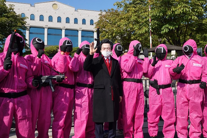 Huh Kyung-young is surrounded by people parodying notorious guards in the Netflix series "Squid Game" after he registered his preliminary presidential candidacy with the national election watchdog on Oct. 18, 2021. (Yonhap)