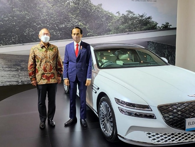 Chung Eui-sun (L), chief of South Korea's Hyundai Motor Group, and Indonesian President Joko Widodo pose for a photo next to the carmaker's electrified Genesis G80 sedan in Jakarta on Oct. 25, 2021, during an event to mark Hyundai's bid to help the Southeast Asian country establish the infrastructure for electric vehicles as part of its expansion strategy. (Yonhap)