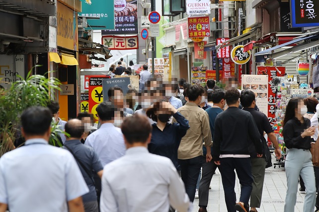 This Sept. 6, 2021, file photo shows people walking along a restaurant-lined street in central Seoul. (Yonhap)