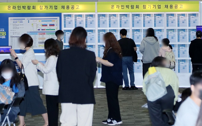 Young jobseekers look at employment information at a job fair in Goyang, north of Seoul, on Oct. 7, 2021. (Yonhap)