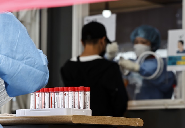A health worker in a protective suit conducts a COVID-19 test at a makeshift clinic in Seoul on Oct. 11, 2021. (Yonhap)
