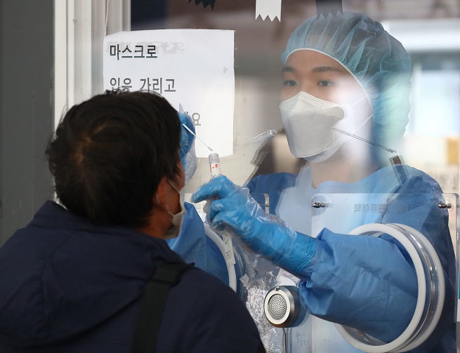 A medical worker takes a sample from a citizen at a COVID-19 testing center in Seoul on Oct. 14, 2021, when the country reported 1,940 new infections. (Yonhap)