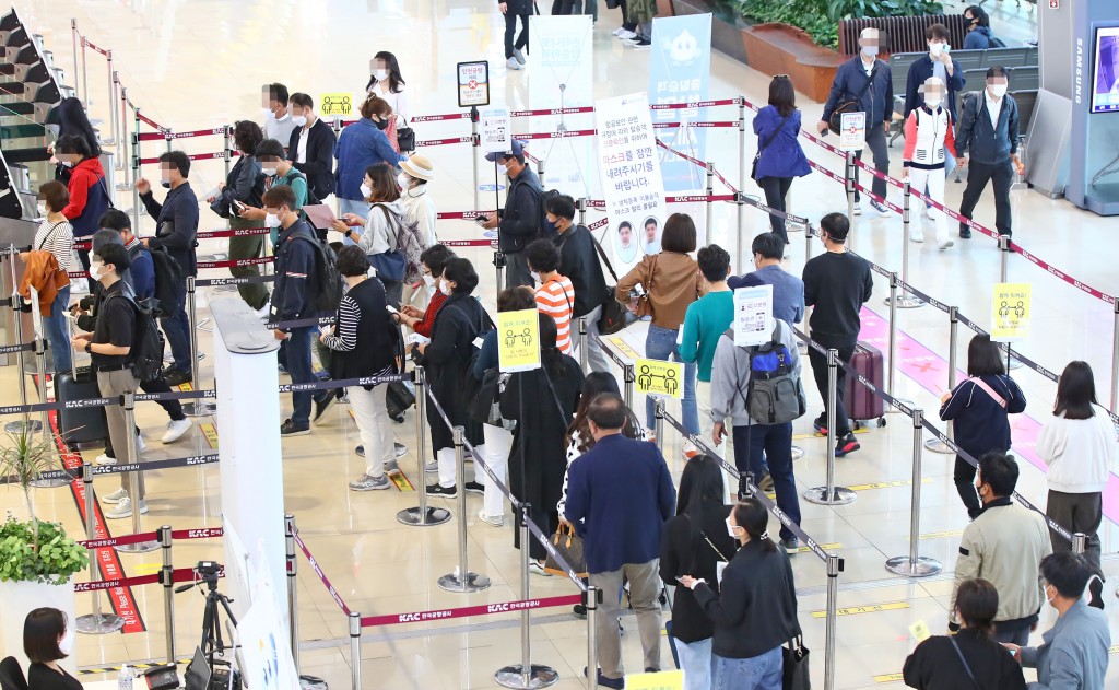 Passengers line up to get their boarding passes at Gimpo International Airport for a flight to South Korea's resort island of Jeju on Oct. 15, 2021, when the government announced eased social distancing rules that will be applied for the next two weeks. (Yonhap)