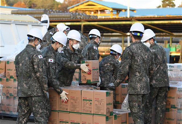 Soldiers move boxes of urea at the Army's First Logistic Support Brigade in Goyang, north of Seoul, on Nov. 11, 2021, to provide them to the civic sector suffering a severe supply shortage due to China's sudden export curbs, in this photo provided by the Korea Defense Daily.