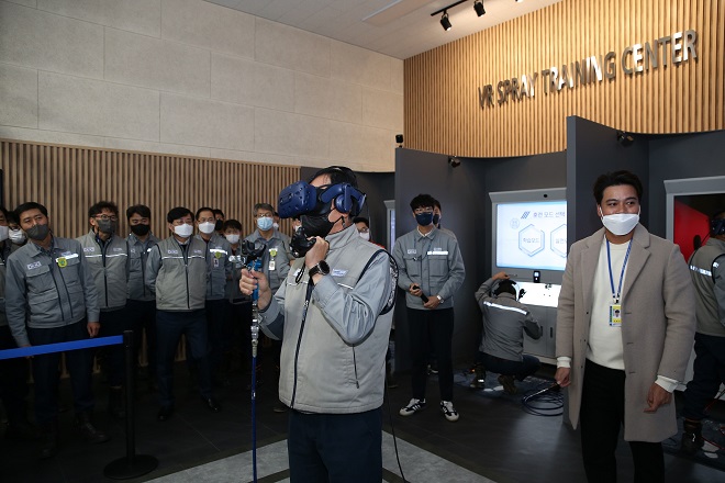 A Daewoo Shipbuilding & Marine Engineering Co. official uses a virtual system for learning how to paint ships, in this photo provided by the shipbuilder on Nov. 29, 2021.