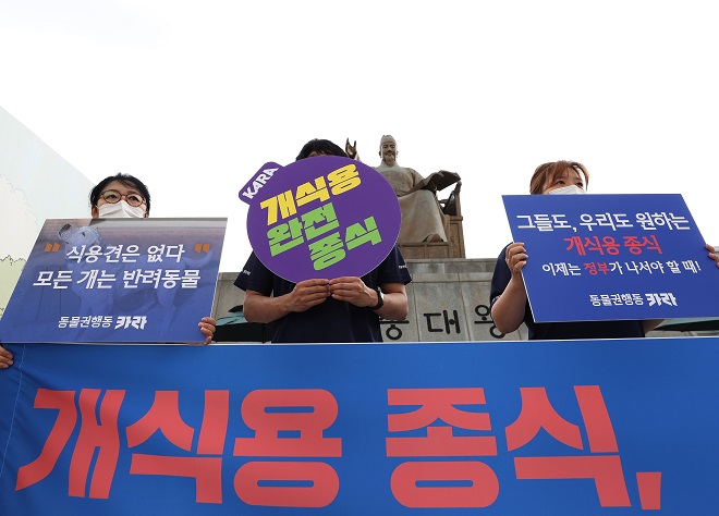 This file photo taken July 9, 2021, shows animal rights activists holding signs demanding the prohibition of dog meat consumption in Seoul. (Yonhap)