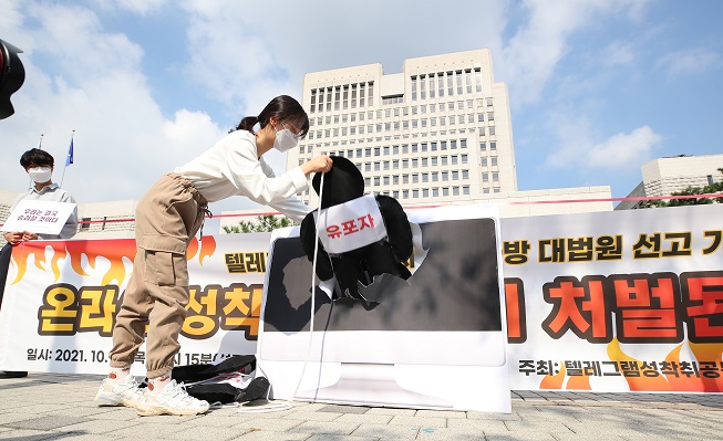 In this file photo, activists hold a protest in front of the Supreme Court in Seoul on Oct. 14, 2021, calling for the court to sentence heavy punishment against producers and distributors of sexually exploitative contents. (Yonhap)