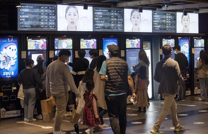 In this file photo taken Oct. 31, 2021, people wait to buy tickets at a movie theater in Seoul. (Yonhap)