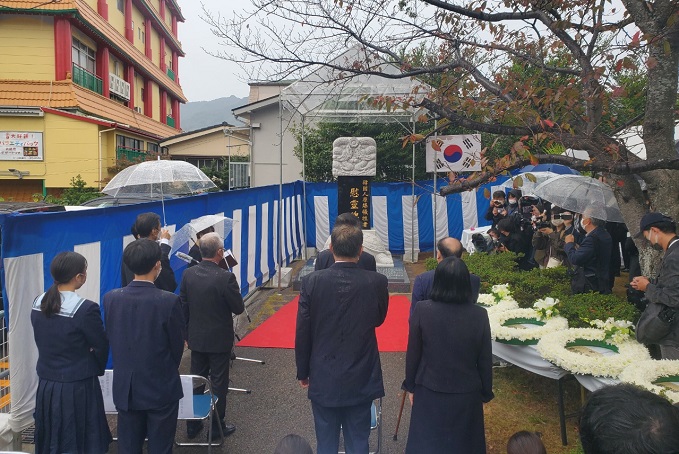 Officials salute the national flag during an unveiling ceremony of a memorial stone for Korean victims of the U.S. atomic bombing of Nagasaki at the Peace Park in Nagasaki, Japan, on Nov. 6, 2021. (Yonhap)
