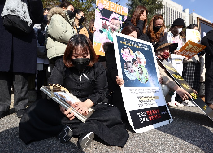 Activists erupt in tears during a picketing campaign in front of the Seoul High Court in southern Seoul on Nov. 26, 2021, after the court commuted a life sentence for the adoptive mother of Jung-in, a toddler abused to death the previous year. (Yonhap)