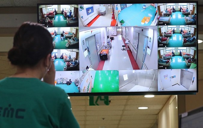 Medical workers look at a monitor showing the fully-occupied intensive care unit for COVID-19 patients of a university hospital in Daejeon, 164 kilometers south of Seoul, on Nov. 29, 2021, making the clinic no longer able to house more of such patients. (Yonhap)