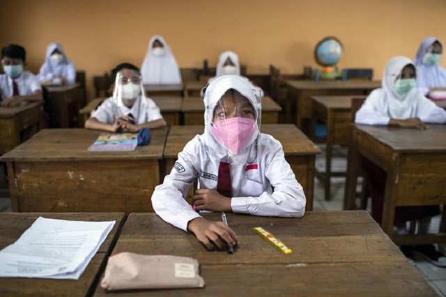 This undated photo, provided by the Korea International Cooperation Agency on Dec. 28, 2021, shows students at a school in Indonesia wearing masks and face shields supplied by the agency.