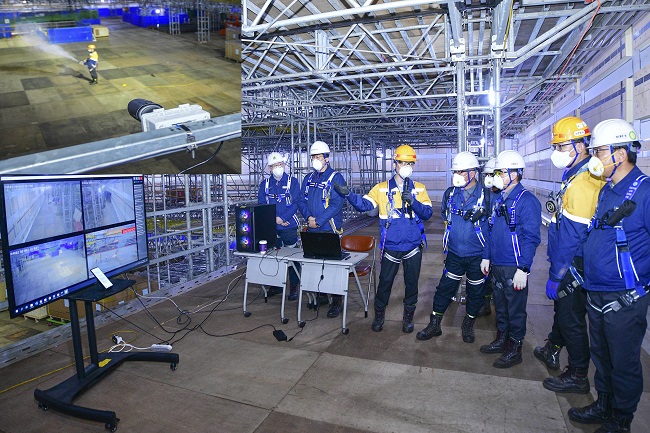 This photo provided by Hyundai Heavy Industries Co. shows engineers demonstrating  vessel fire surveillance system.