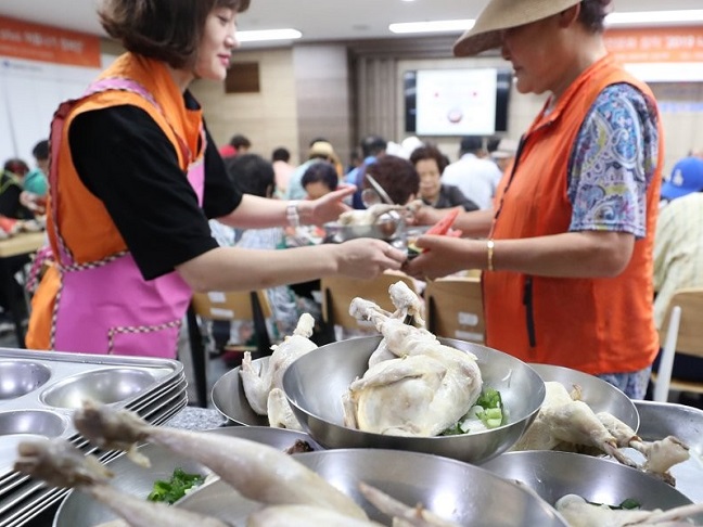 Volunteers prepare "samgyetang," a traditional Korean soup made with a whole young chicken stuffed with ginseng, sticky rice and garlic, for underprivileged senior citizens at a community welfare center in Daegu, some 300 km southeast of Seoul, on June 20, 2019. (Yonhap)