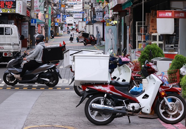 Motorbikes for food delivery are parked along a street in Seoul. (Yonhap)