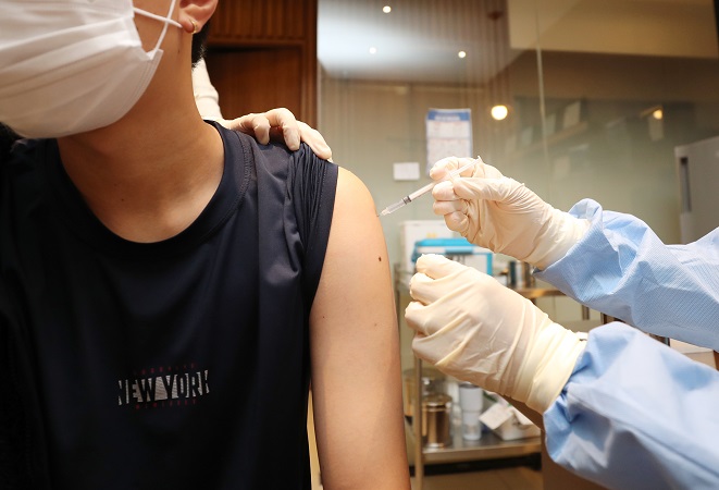 This file photo shows a young person getting vaccinated against COVID-19. (Yonhap)
