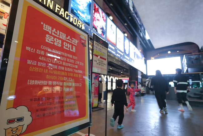 In this file photo taken on Nov. 1, 2021, a Seoul movie theater posts an announcement on its operation of a vaccine pass cinema that allows fully vaccinated people to have popcorn and sodas while viewing films. (Yonhap)
