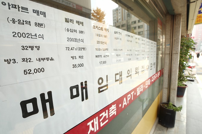 This file photo, taken on Nov. 14, 2021, shows signs put up at a realtor's office in Seoul that provide information about transactions of apartments and houses. (Yonhap)