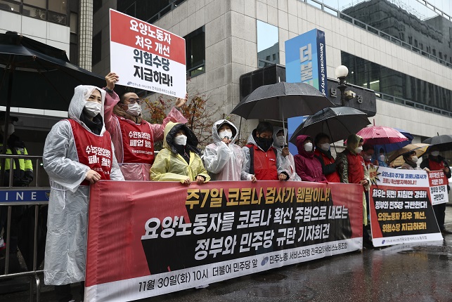 Caregivers hold a press conference in western Seoul on Nov. 30, 2021 to demand improved working conditions. (Yonhap)