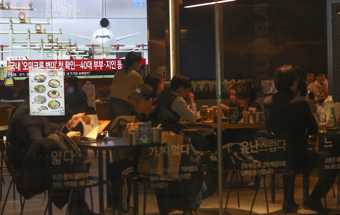 A restaurant in downtown Seoul shows a TV screen airing a news report on the first cases of the omicron COVID-19 variant confirmed in South Korea on Dec. 1, 2021. (Yonhap)