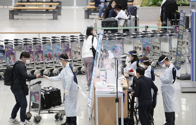 Quarantine officials guide foreign entrants at Terminal 1 of Incheon International Airport, west of Seoul, on Dec. 3, 2021. (Yonhap)